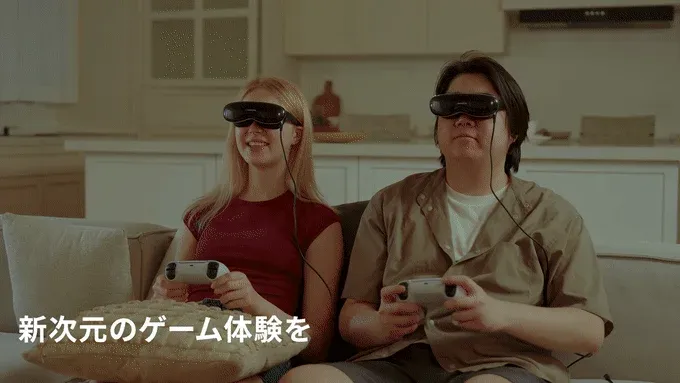 ソファに座った男女が、それぞれVR/ARヘッドセットとゲームコントローラーを装着し、楽しそうにゲームをプレイしている様子です。新しいゲーム体験の広告のように見えます。