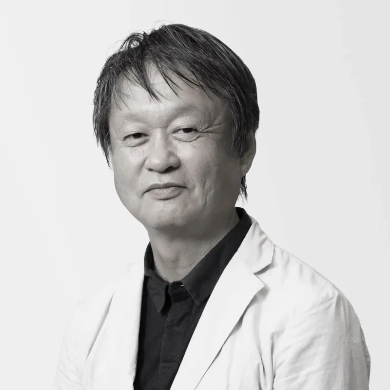 白いジャケットと黒いシャツを着た中年男性のモノクロポートレート