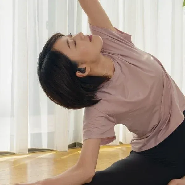 イヤホンを装着してヨガをする女性