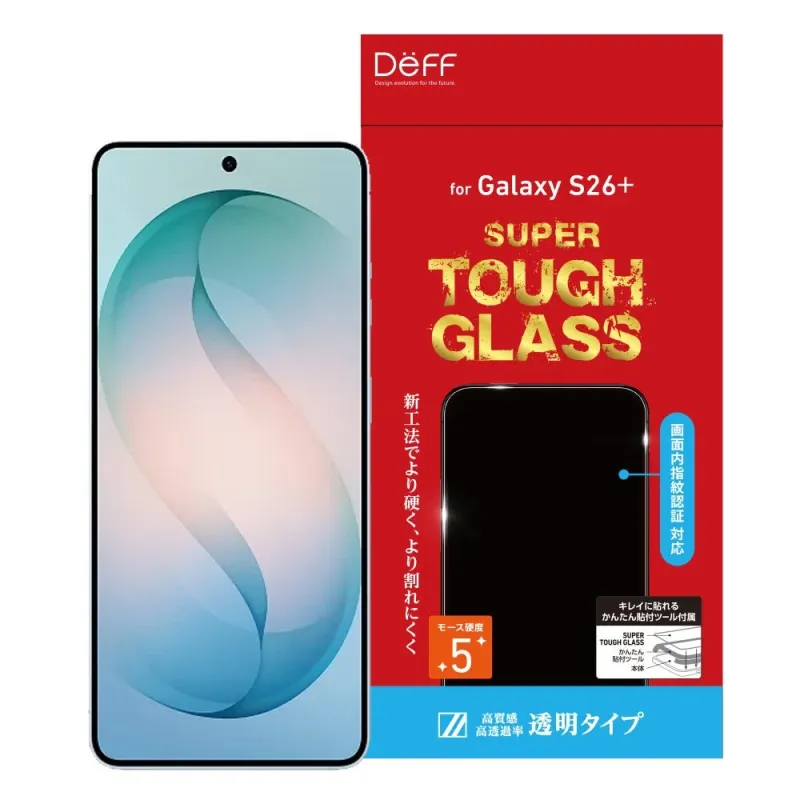 Deff製のGalaxy S26+用「SUPER TOUGH GLASS」液晶保護ガラスのパッケージと、製品が適用されたスマートフォンのイメージです。新工法による高い硬度と割れにくさ、画面内指紋認証対応、簡単な貼り付けツール付属が特徴で、透明タイプで高質感・高透過率をアピールしています。