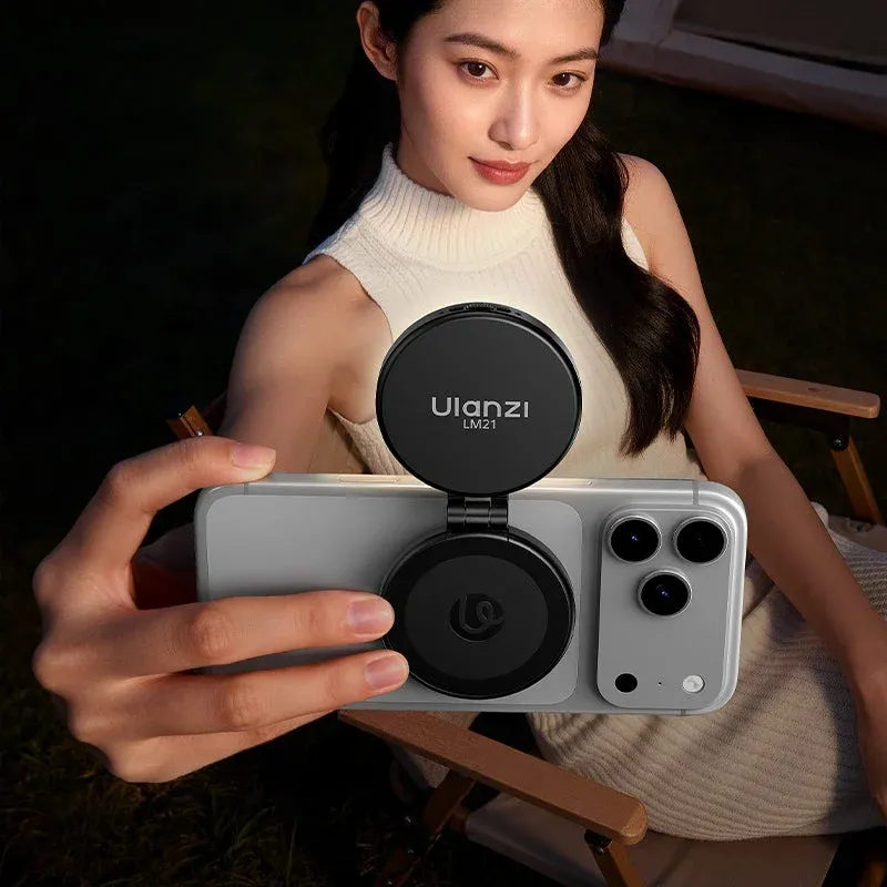 女性がスマートフォンにUlanzi LM21の補助ライトを取り付けて自撮りしている様子。夜間や暗い場所での撮影に役立つガジェットが顔を明るく照らしています。