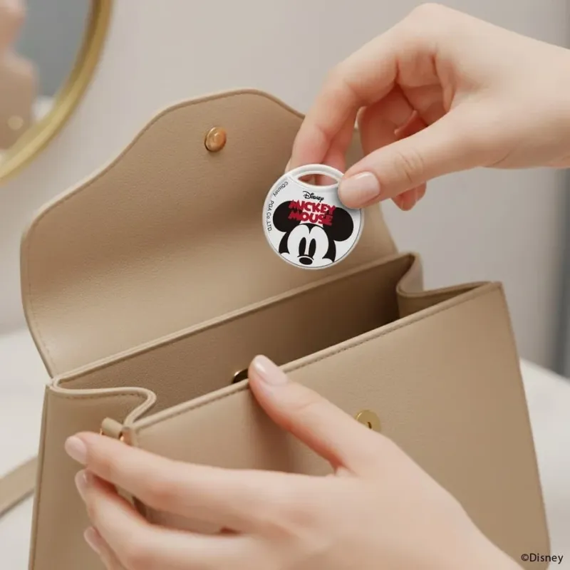 ミッキーマウスのキーホルダーをハンドバッグに入れる様子