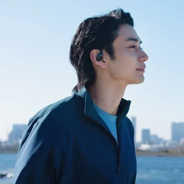 イヤホンを装着して街並みを歩く男性