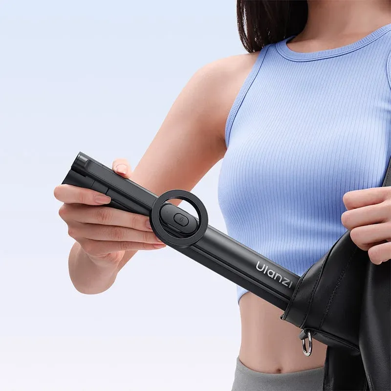 女性がUlanziブランドの黒いデバイス（セルフィースティックまたはコンパクト三脚と思われる）を黒いバッグに収納している様子です。持ち運びやすさや携帯性を強調する場面です。