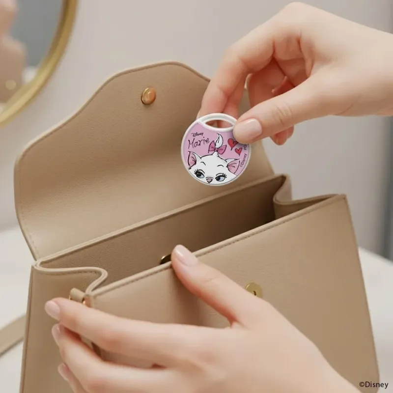 マリーデザインの忘れ物防止タグをハンドバッグに入れる様子