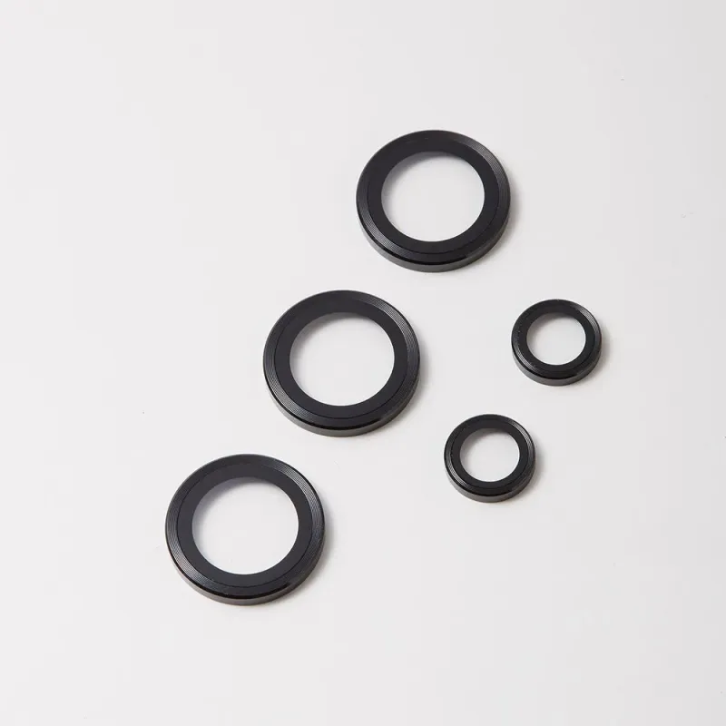 白い背景に、様々なサイズの黒い円形部品が5つ配置されています。これらは精密機械用のリングやシールのように見えます。