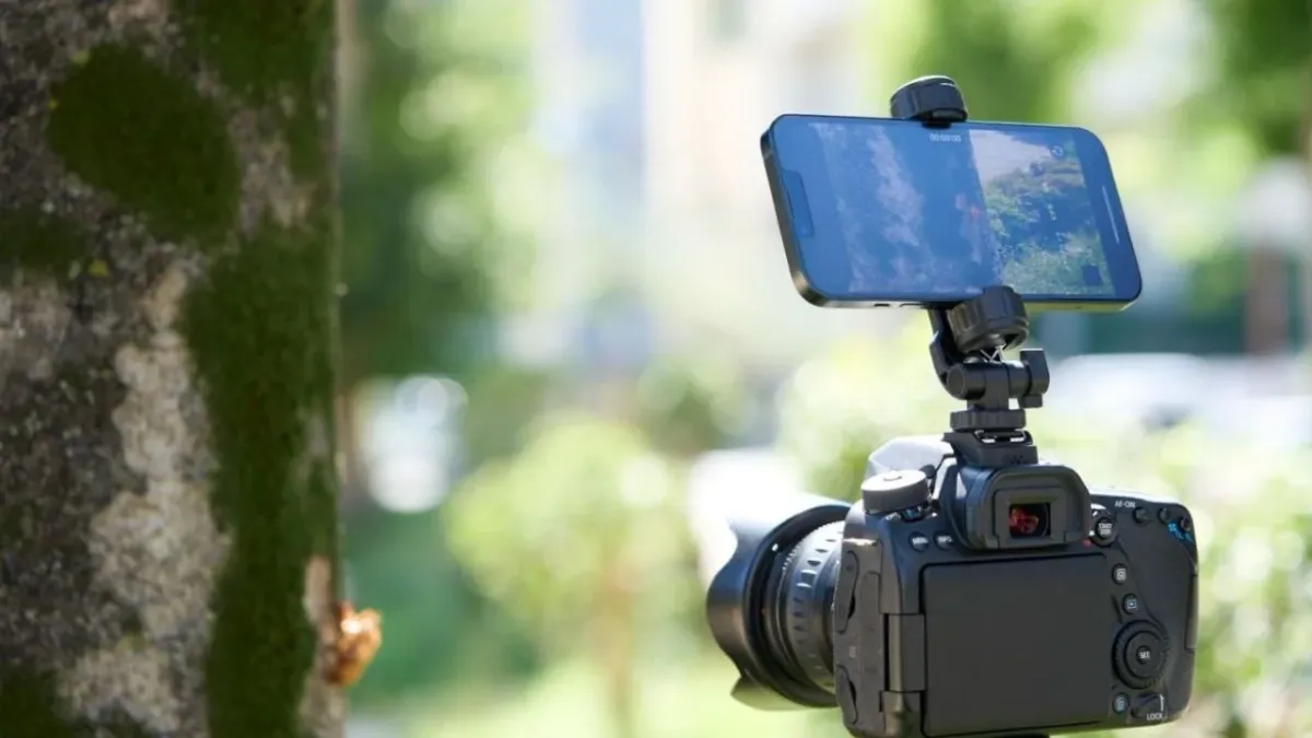 デジタル一眼レフカメラにスマートフォンが取り付けられ、外部モニターとして使用されている様子