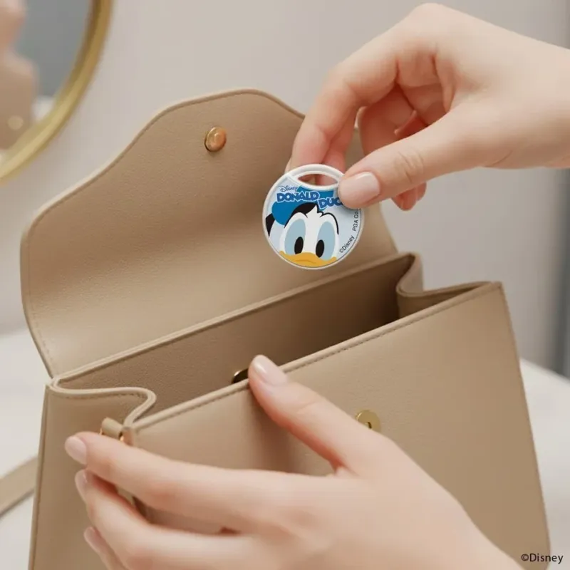 ドナルドダックのキーホルダーをハンドバッグに入れる様子