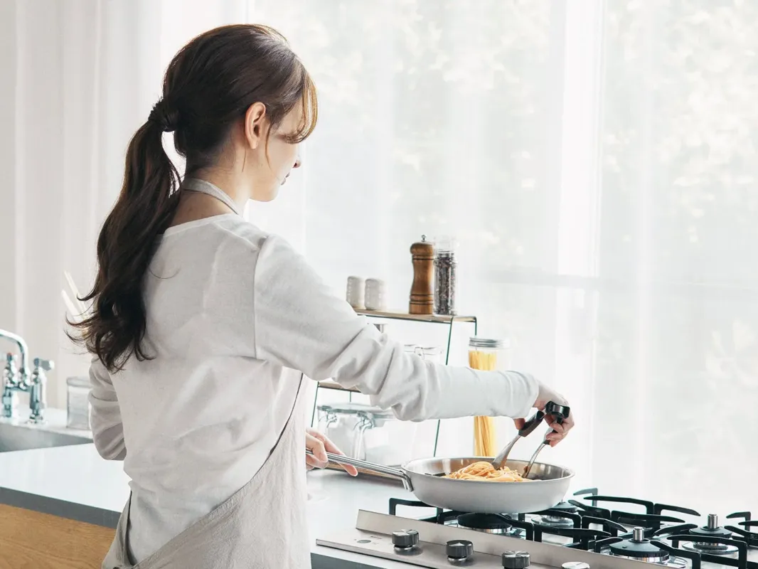 女性がパスタを調理する様子