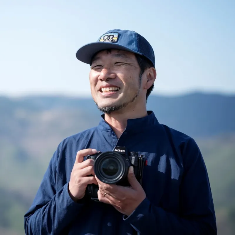 屋外で笑顔の男性とカメラ