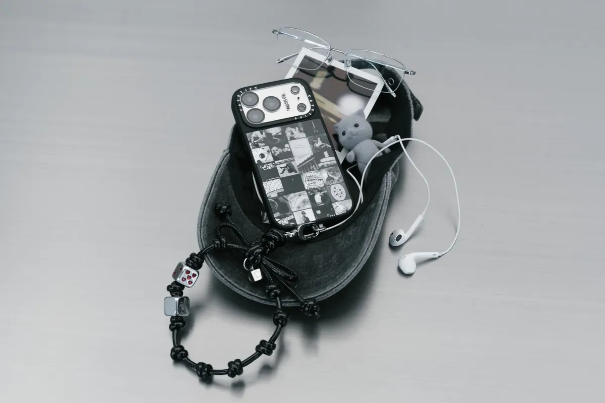 スマホ、メガネ、イヤホン、猫のぬいぐるみなどが写った静物写真