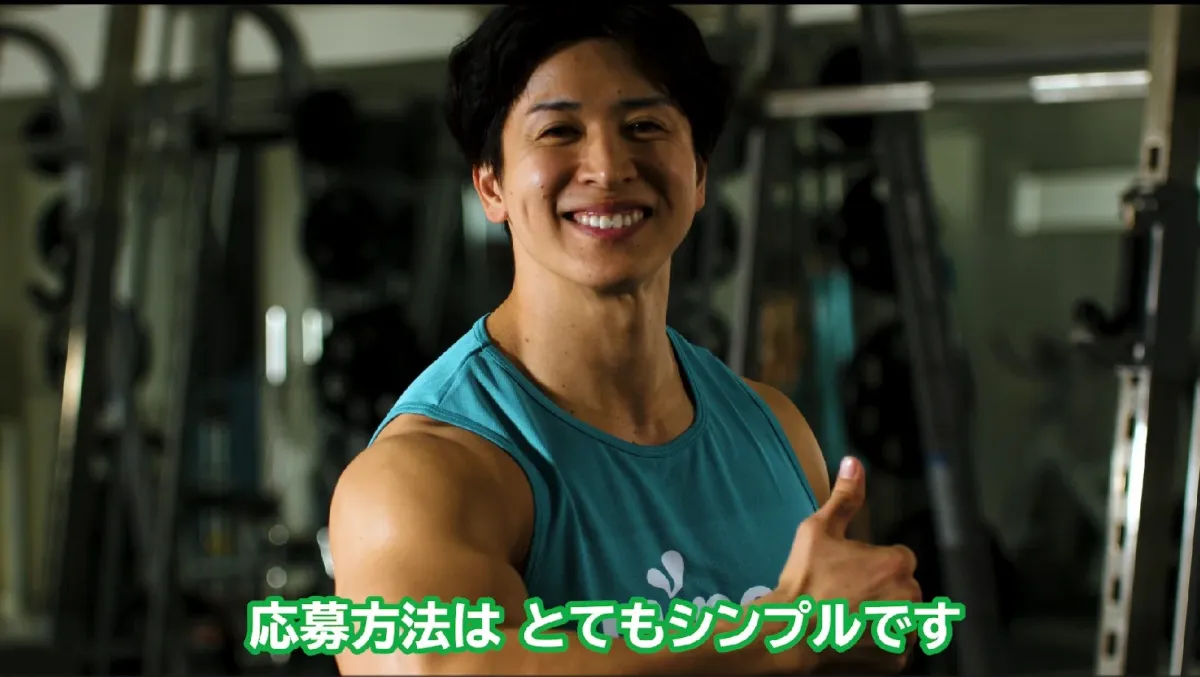 ジムで笑顔の男性がサムズアップしている画像