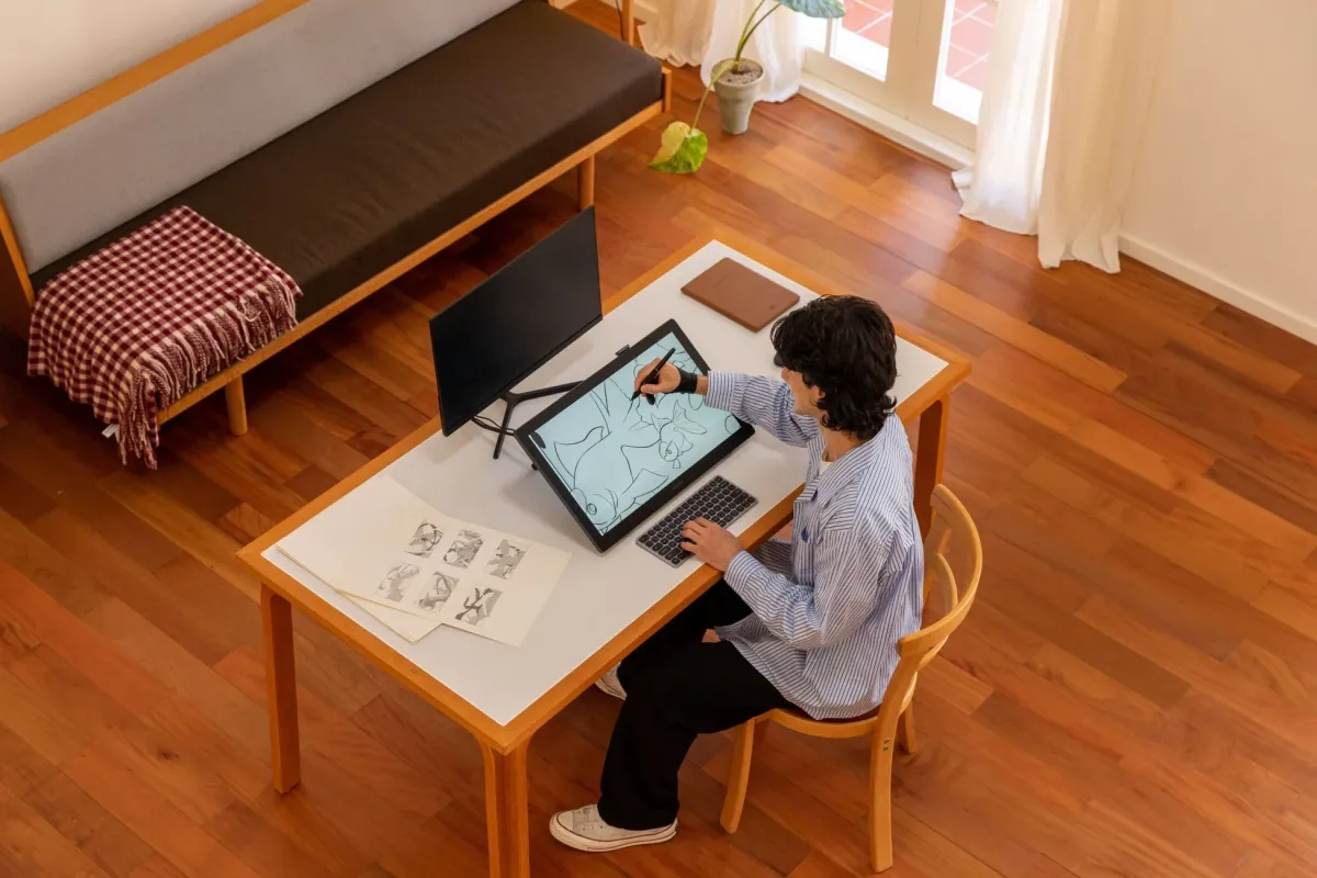 リビングでデジタル描画タブレットを使う人物